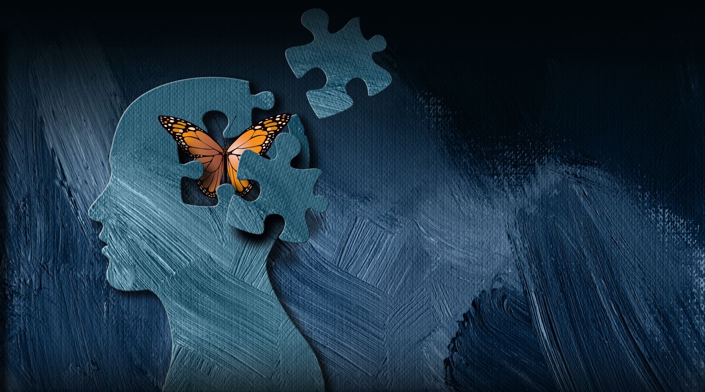 Silhouette of a head with a missing puzzle piece, revealing an orange butterfly emerging, symbolising transformation and creativity.